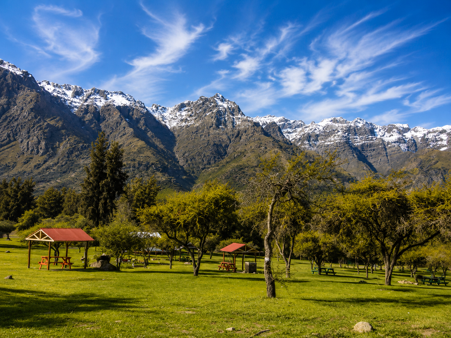 Área de descanso entre árboles y montañas de la Reserva Río de los Cipreses